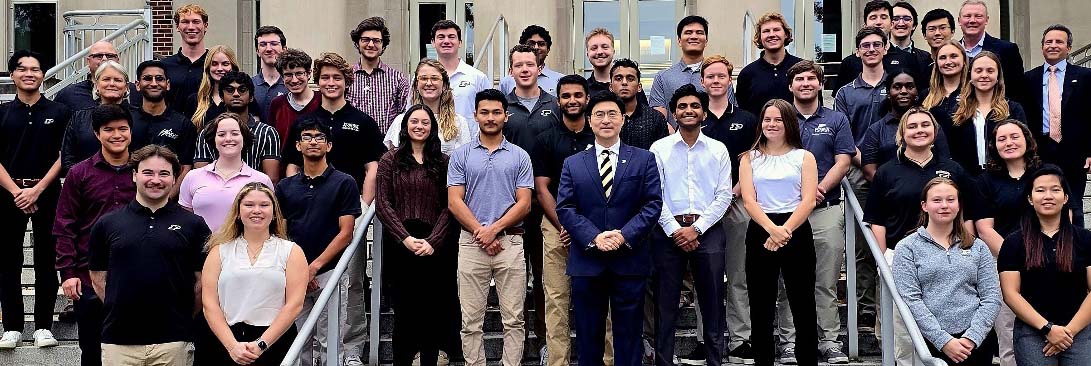 DCTC cohort, President Mung Chiang, and other leadership pose on the steps of Hovde Hall